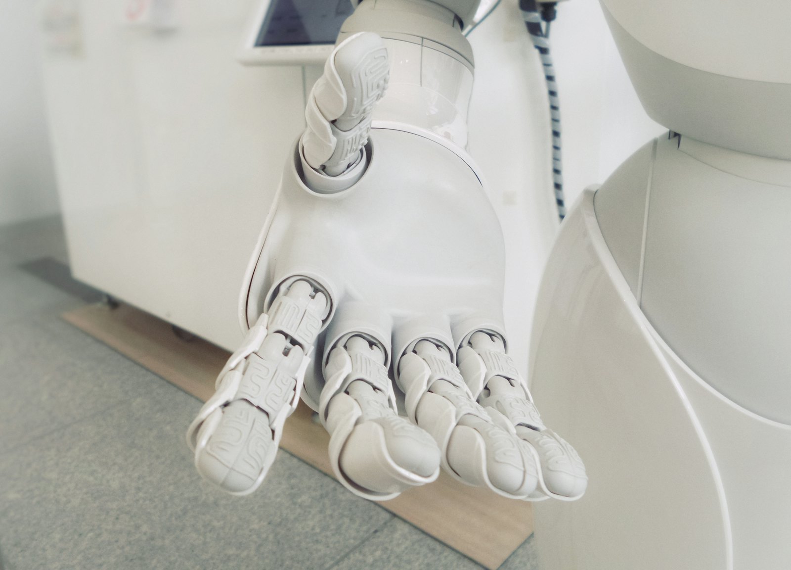 A white robotic hand reaching forward