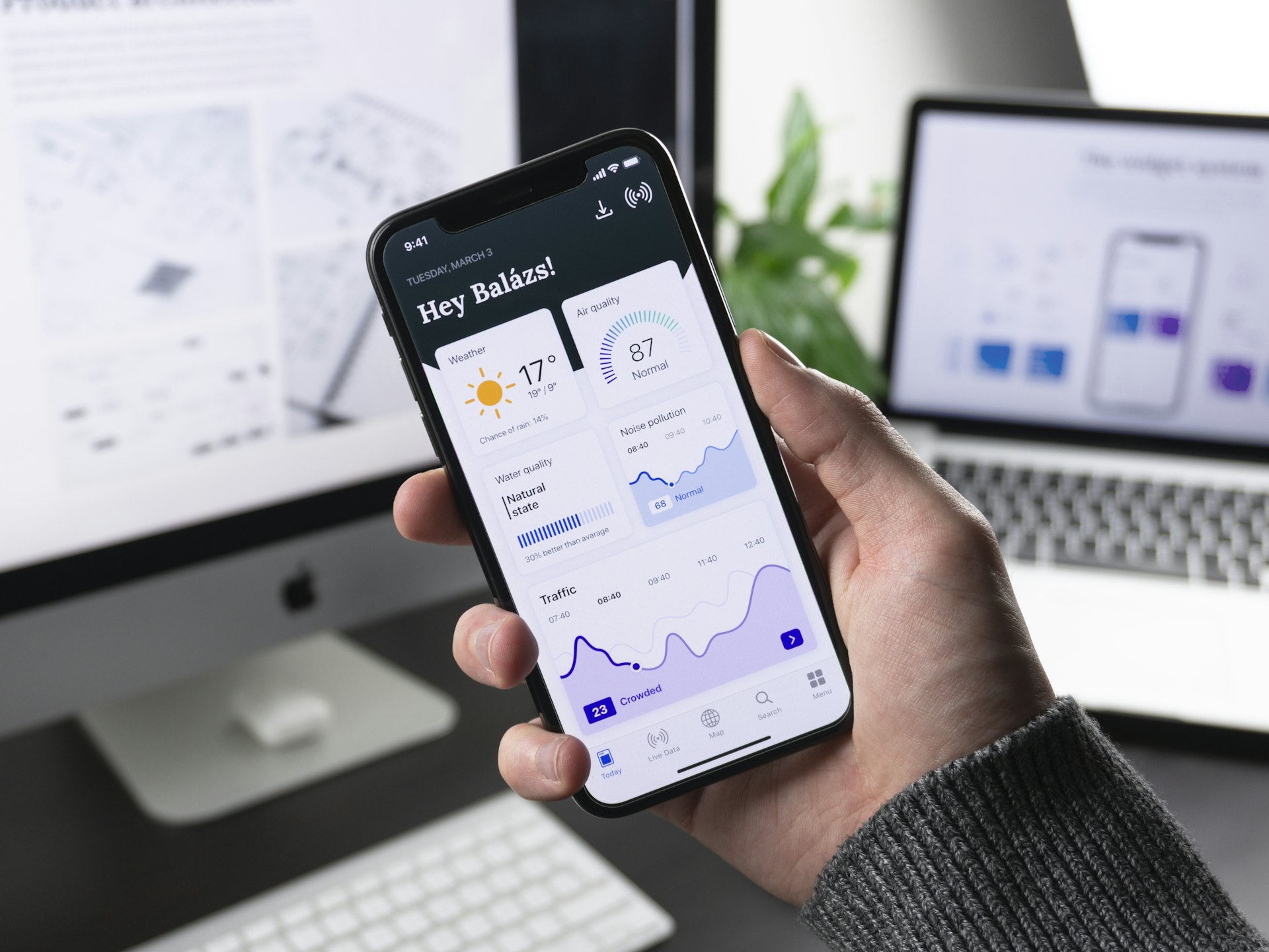 A hand holding a smartphone showing a clean app dashboard
